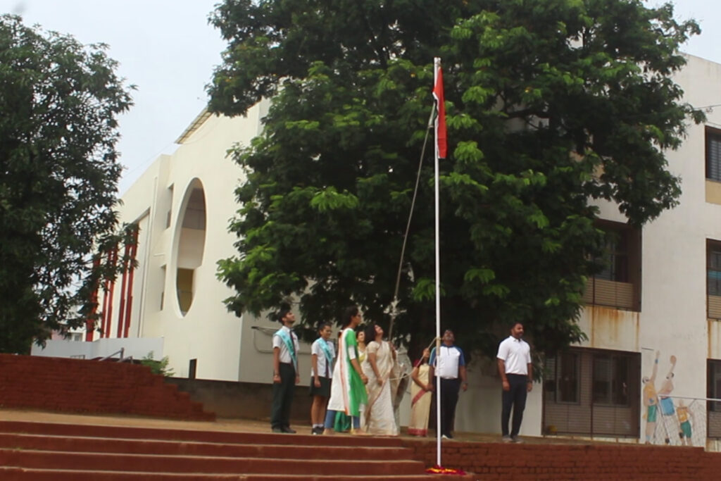Principal Dr. Archana Mishra along with students and teachers saluting the tri colour